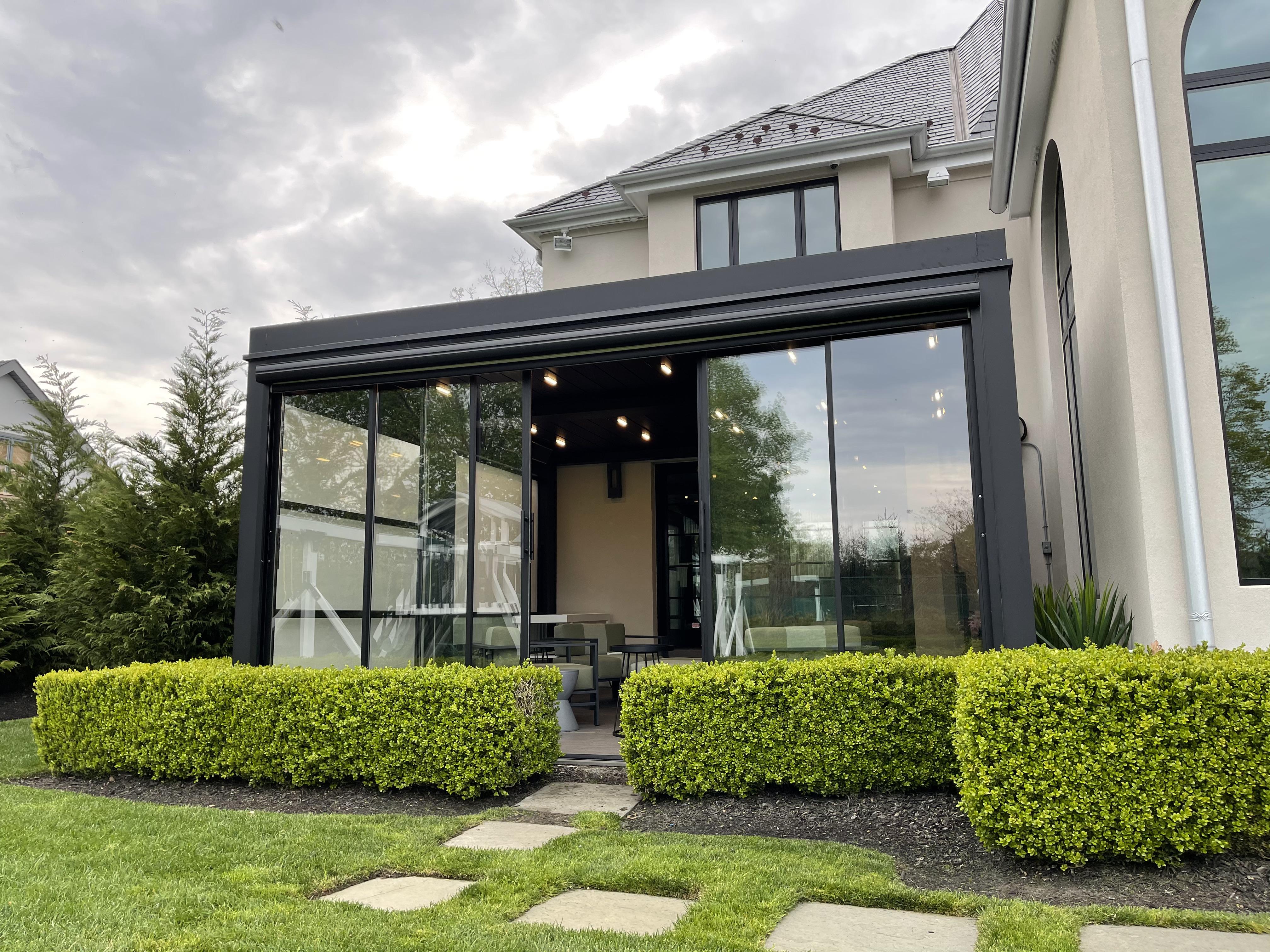 Bioclimatic pergola with sliding glass panels and recessed track lighting attached to a modern house in Nairobi Kenya